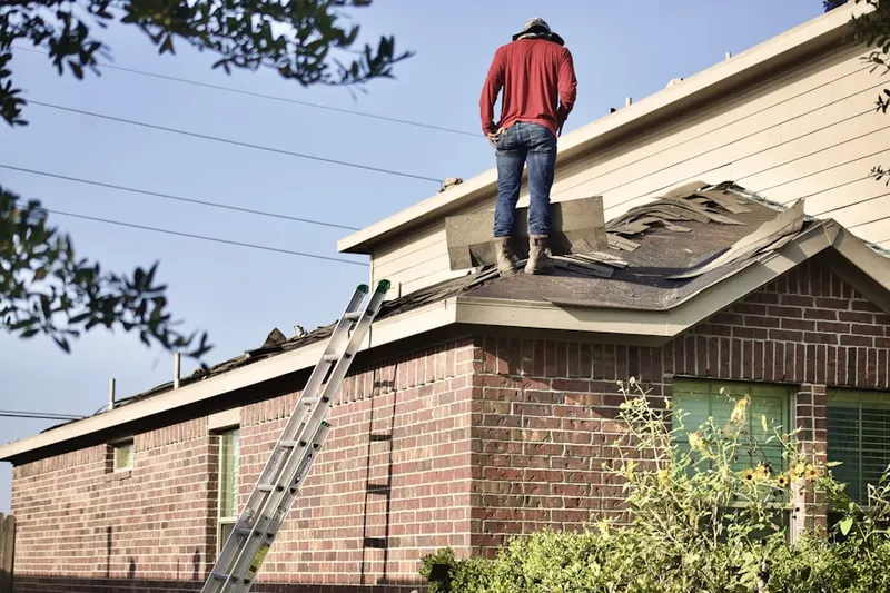 Professional roofer working on a residential roof in Scotia